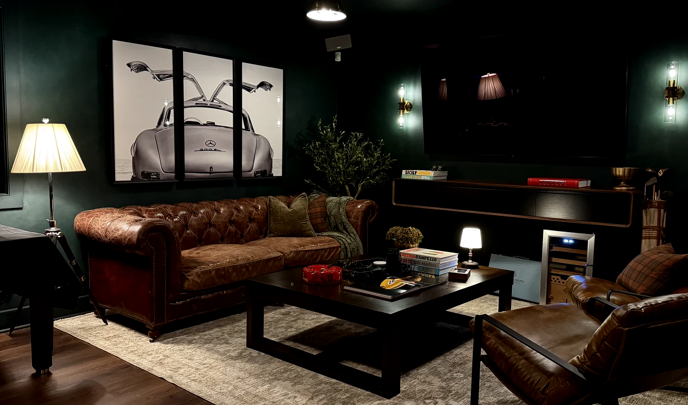 Members lounge with dark green walls, a leather chesterfield sofa, and a private seating area